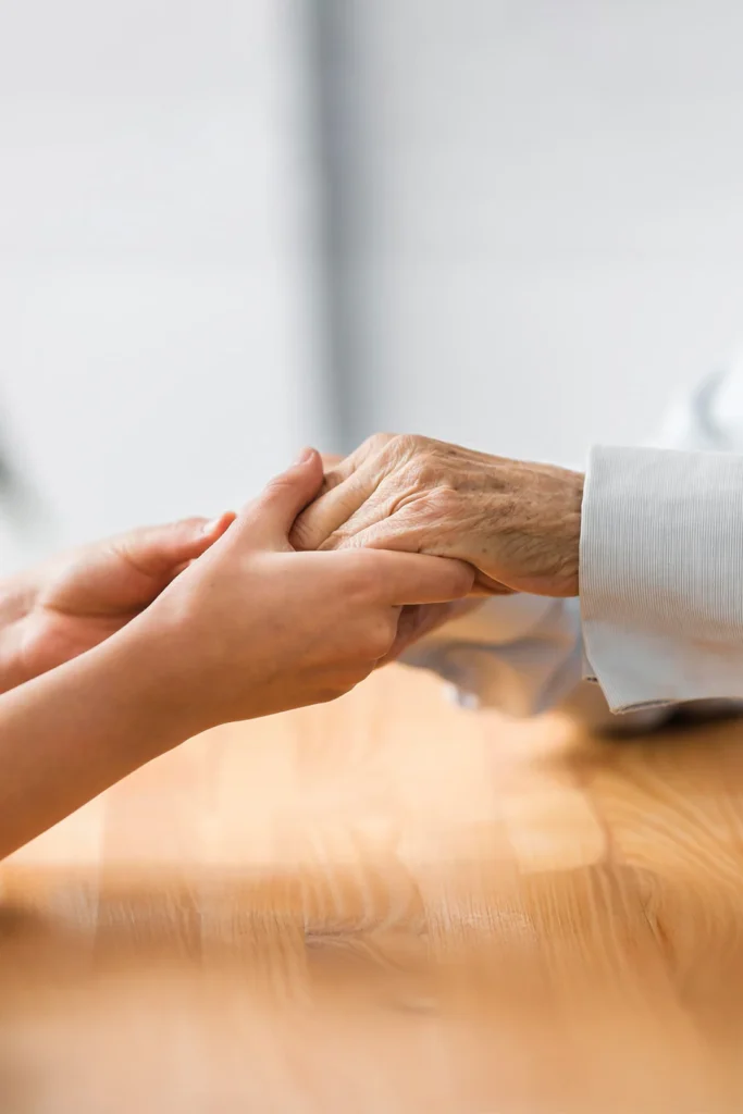 A Young Person Holds The Hands Of An Elderly Person