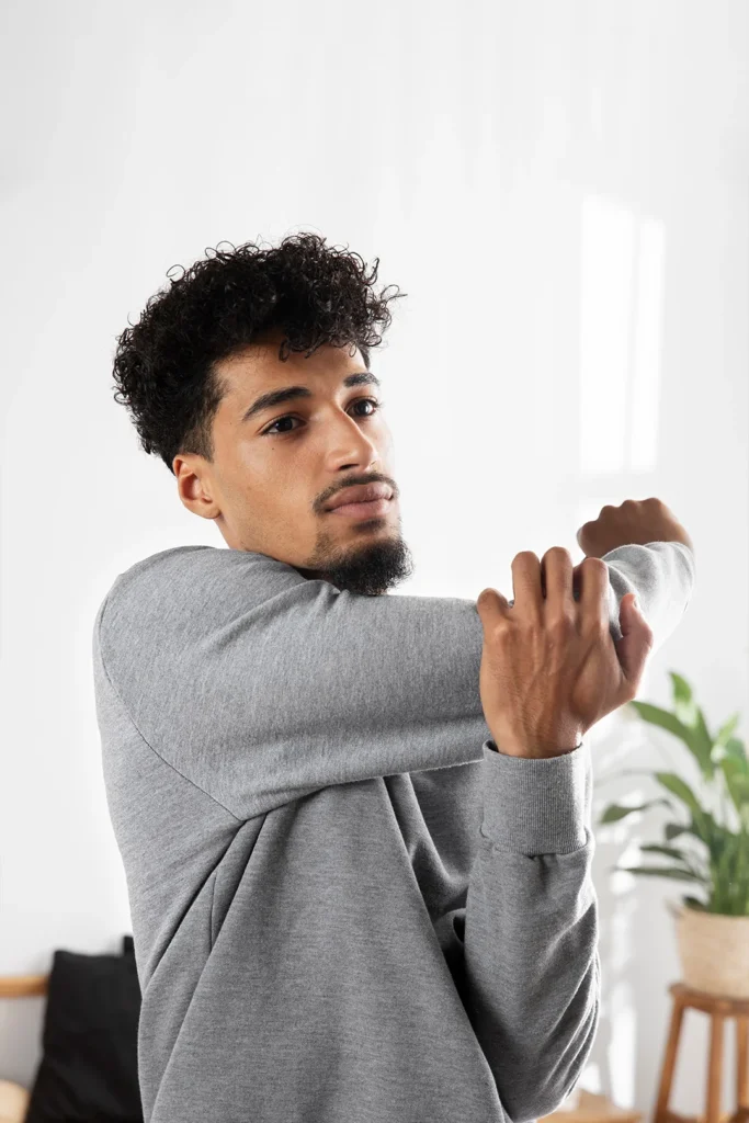 Man Stretching Out Arm To Relieve His Shoulder Pain